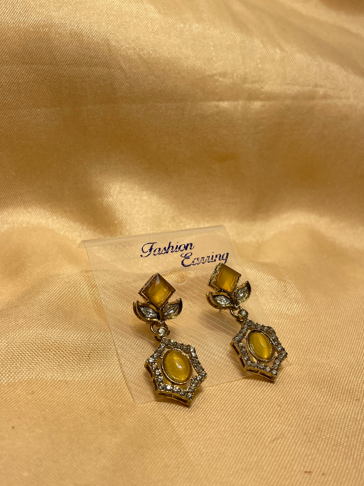 Antique Gold / Bronze Amber Stone Drop Earrings on a Metal Jewelry Display