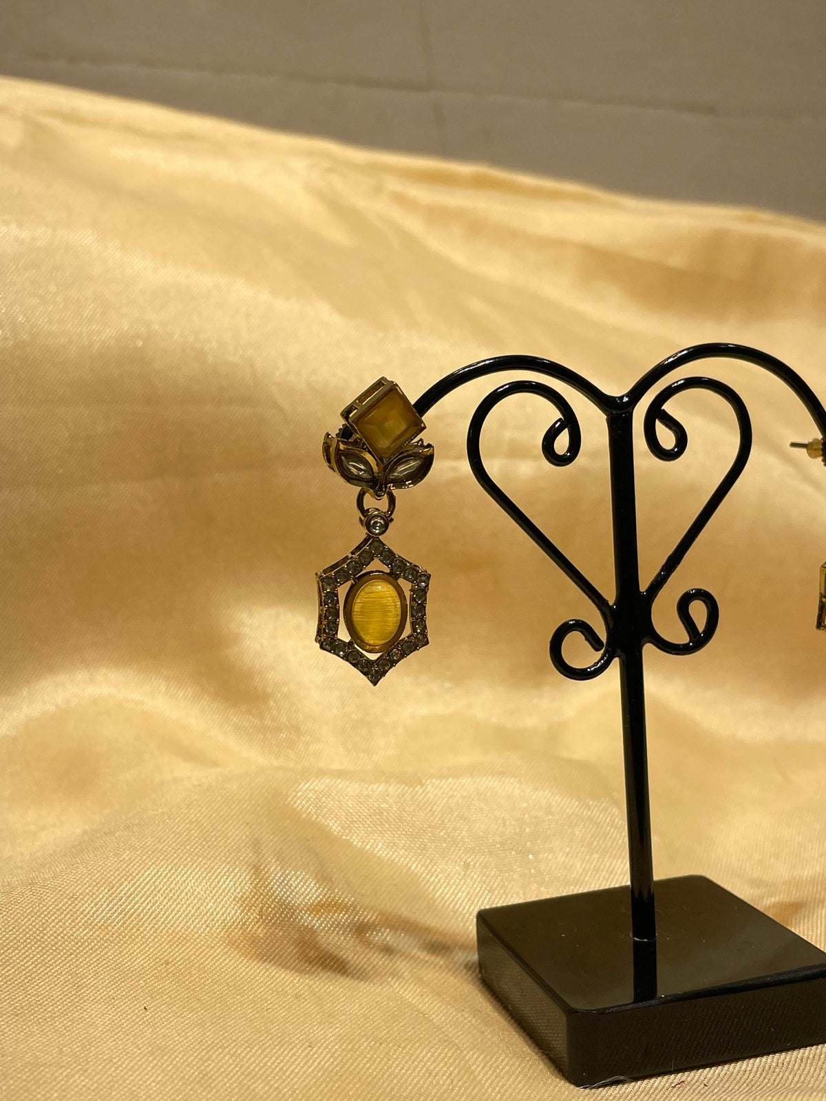 Antique Gold / Bronze Amber Stone Drop Earrings on a Metal Jewelry Display