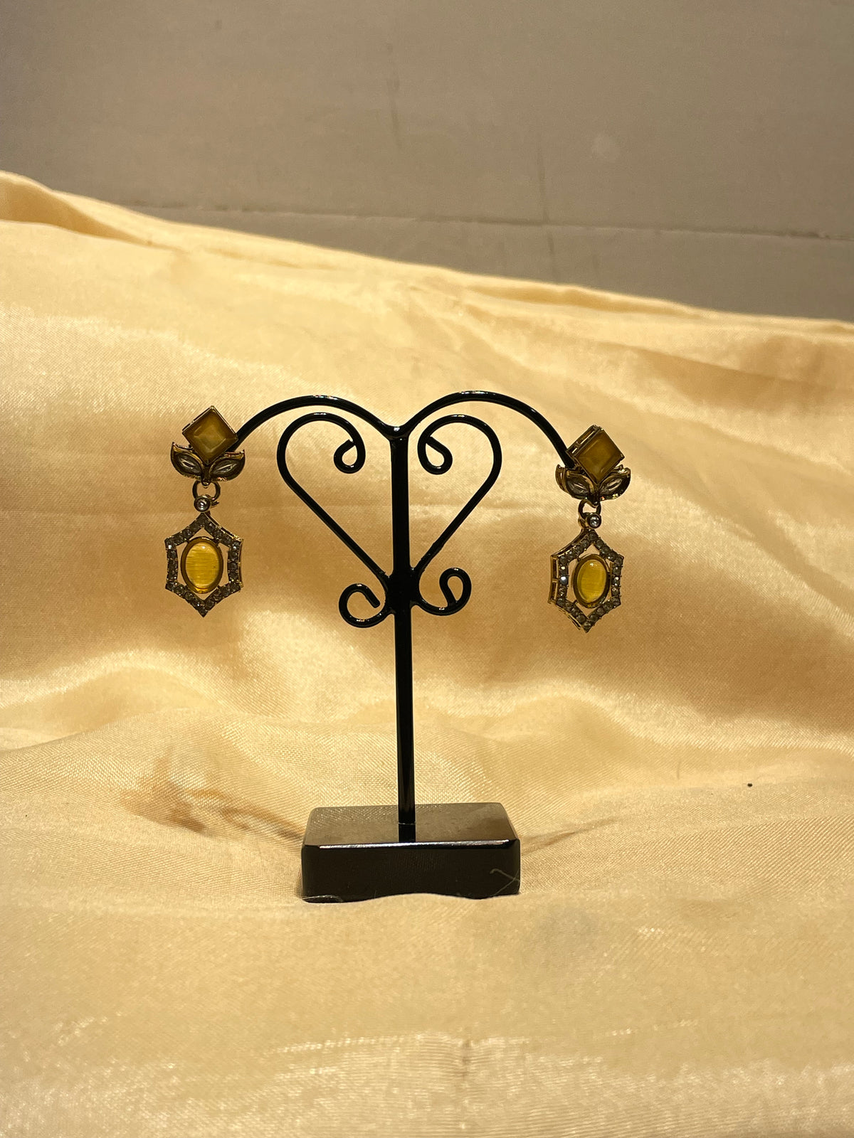 Antique Gold / Bronze Amber Stone Drop Earrings on a Metal Jewelry Display