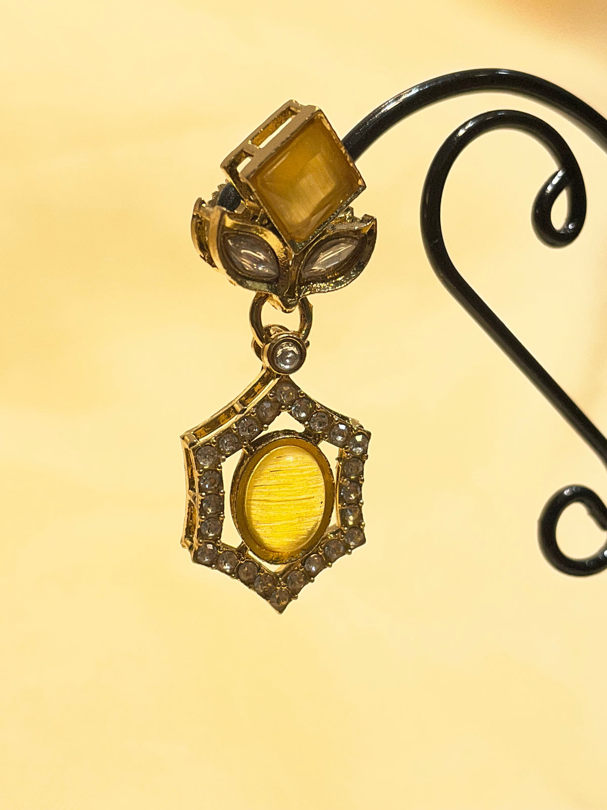 Antique Gold / Bronze Amber Stone Drop Earrings on a Metal Jewelry Display